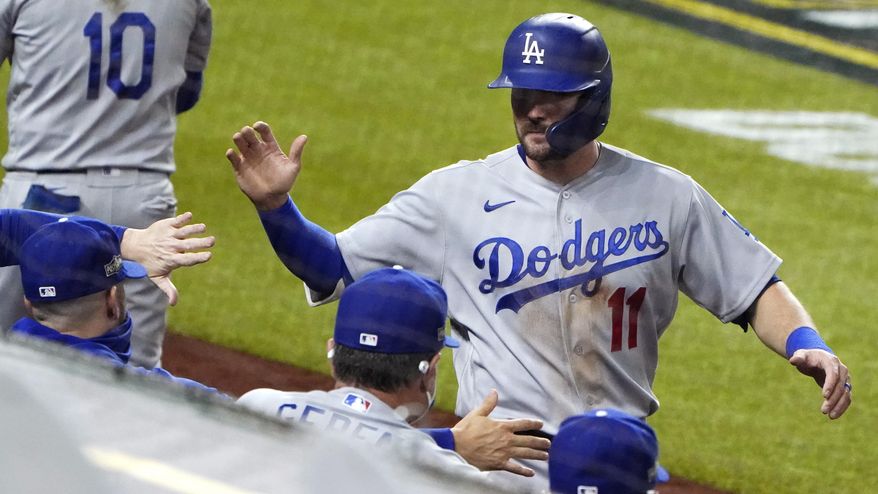 Los Angeles Dodgers&#x27; A.J. Pollock (11) is congratulated after scoring on a sacrifice fly by Mookie Betts against the San Diego Padres during the fifth inning in Game 3 of a baseball National League Division Series Thursday, Oct. 8, 2020, in Arlington, Texas. (AP Photo/Sue Ogrocki)