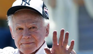 In this June 12, 2016 file photo, former New York Yankees pitcher Whitey Ford waves to fans from outside the dugout at the Yankees&#39; annual Old Timers Day baseball game in New York. A family member tells The Associated Press on Friday, Oct. 9, 2020 that Ford died at his Long Island home Thursday night.  (AP Photo/Kathy Willens, File)  **FILE**