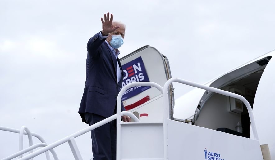 Democratic presidential candidate former Vice President Joe Biden waves as he boards his campaign plane at New Castle Airport, Saturday, Oct. 10, 2020, in New Castle, Del., en route to Erie, Pa. (AP Photo/Carolyn Kaster)