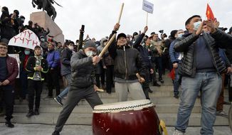 Supporters of former President Almazbek Atambayev bang on the drum during a rally on the central square in Bishkek, Kyrgyzstan, Friday, Oct. 9, 2020. Sooronbai Jeenbekov, the embattled president of Kyrgyzstan, has moved to end the political turmoil that followed a disputed parliamentary election, ordering a state of emergency in the capital. Jeenbekov has faced calls to resign by protesters who stormed government buildings after Sunday’s parliamentary vote was reportedly swept by pro-government parties. Protesters freed former President Almazbek Atambayev, who was jailed on charges seen by his supporters as a political vendetta. (AP Photo/Vladimir Voronin)