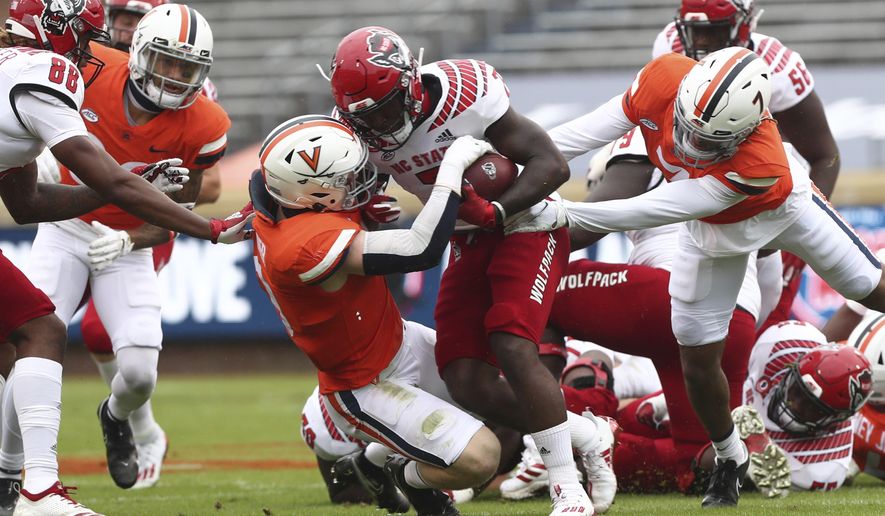 North Carolina State running back Zonovan Knight is tackled by Virginia defenders during an NCAA college football game, Saturday, Oct. 10, 2020, at Scott Stadium in Charlottesville, Va. (Erin Edgerton/The Daily Progress via AP)