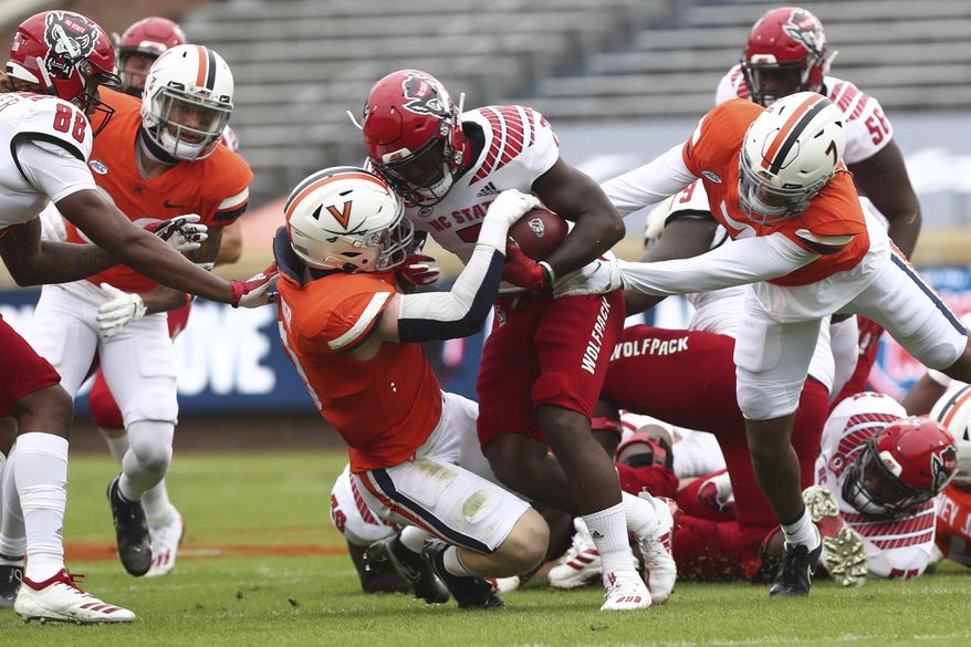 North Carolina State running back Zonovan Knight is tackled by Virginia defenders during an NCAA college football game, Saturday, Oct. 10, 2020, at Scott Stadium in Charlottesville, Va. (Erin Edgerton/The Daily Progress via AP)