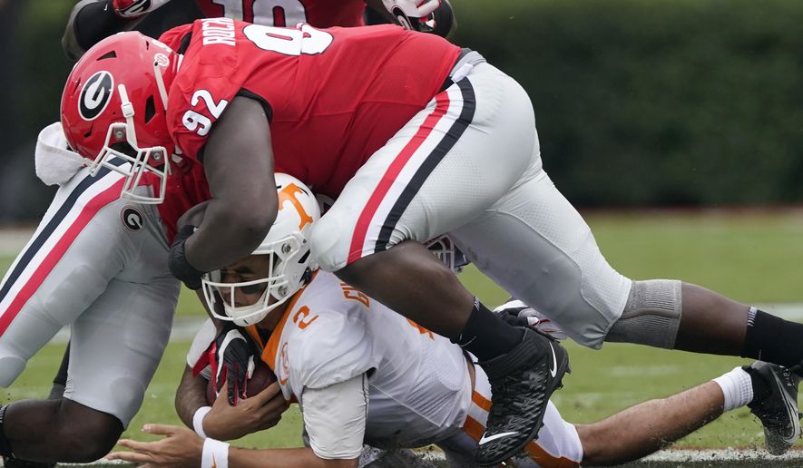 Tennessee quarterback Jarrett Guarantano (2) is brought down by Georgia defensive lineman Julian Rochester (92) after a short run in the first half of an NCAA college football game Saturday, Oct. 10, 2020, in Athens, Ga. (AP Photo/John Bazemore)