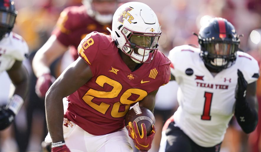 Iowa State running back Breece Hall (28) runs from Texas Tech linebacker Krishon Merriweather (1) during the first half of an NCAA college football game, Saturday, Oct. 10, 2020, in Ames, Iowa. (AP Photo/Charlie Neibergall)