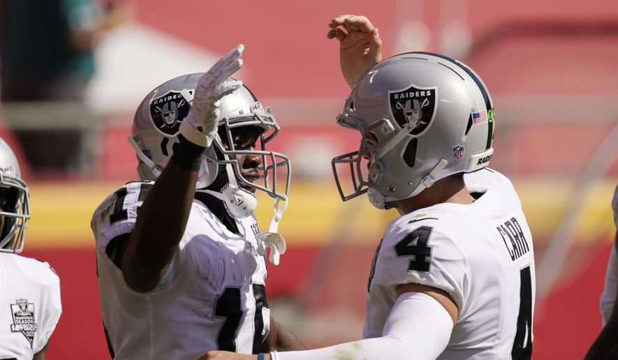 Las Vegas Raiders wide receiver Nelson Agholor, left, celebrates with quarterback Derek Carr after catching a 59-yard touchdown pass during the first half of an NFL football game against the Kansas City Chiefs, Sunday, Oct. 11, 2020, in Kansas City. (AP Photo/Charlie Riedel)
