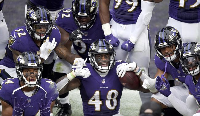 Baltimore Ravens inside linebacker Patrick Queen (48) and teammates pose for a photographer after he returned a fumble recovery 53 yards for a touchdown against the Cincinnati Bengals during the second half of an NFL football game, Sunday, Oct. 11, 2020, in Baltimore. The Ravens won 27-3. (AP Photo/Gail Burton)