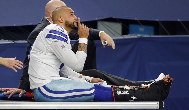 Dallas Cowboys quarterback Dak Prescott (4) points skyward as he is carted off the field after sustaining a leg injury in the third quarter of an NFL football game against the New York Giants in Arlington, Texas, Sunday, Oct. 11, 2020. (Tom Fox/The Dallas Morning News via AP)