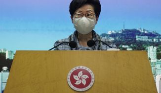 Hong Kong Chief Executive Carrie Lam listens to a reporter&#39;s questions during a press conference in Hong Kong, Monday, Oct. 12, 2020. Lam said Monday that her annual policy address scheduled for this week will be delayed until she travels to Beijing to ask the Chinese central government for help with measures to help her city&#39;s battered economy. (AP Photo/Vincent Yu)