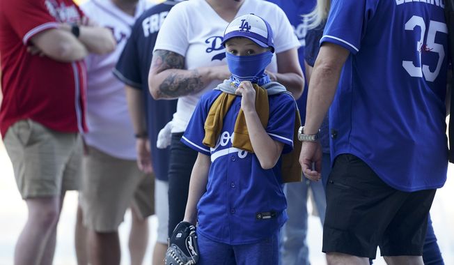 Fans arrive before Game 1 of a baseball National League Championship Series between the Los Angeles Dodgers and the Atlanta Braves Monday, Oct. 12, 2020, in Arlington, Texas. (AP Photo/Eric Gay)