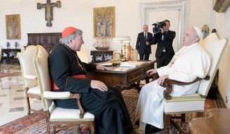 Pope Francis, right, sits at a table with Cardinal George Pell on the occasion of their private meeting at the Vatican, Monday, Oct. 12, 2020. The Pope warmly welcomed Cardinal for a private audience in the Apostolic Palace after the cardinal’s sex abuse conviction and acquittal in Australia.  (Vatican News via AP)