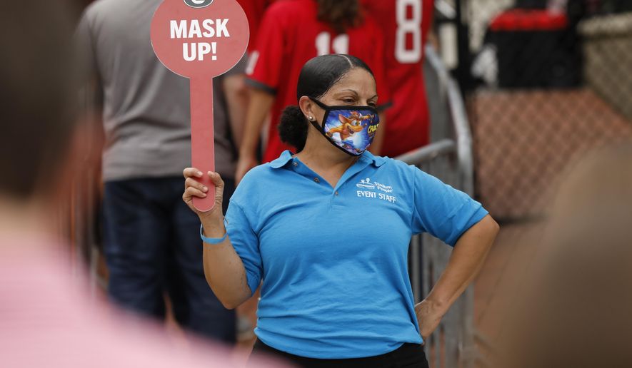 Security reminds fans to mask up before entering Sanford Stadium before the start of the Georgia-Tennessee NCAA college football game in Athens, Ga., on Saturday, Oct. 10, 2020. (Joshua L. Jones/Athens Banner-Herald via AP)