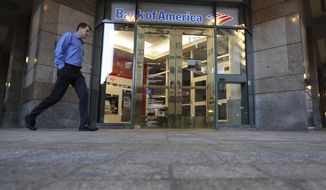 FILE - In this Oct. 14, 2019 file photo a passer-by walks past the entrance to a Bank of America ATM, in Boston.  Bank of America Corp. says profit fell 15.6% to $4.88 billion in the third quarter from $5.78 billion a year ago. The bank, based in Charlotte, North Carolina, said Wednesday, Oct. 14, 2020, that it had earnings of 51 cents per share.  (AP Photo/Steven Senne, File)