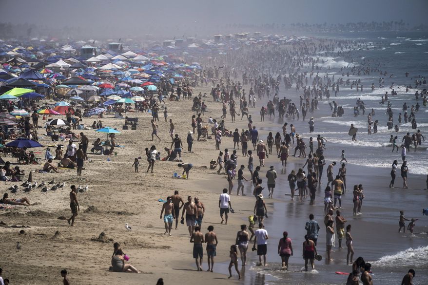 FILE - In this Saturday, Sept. 5, 2020 file photo, people crowd the beach in Huntington Beach, Calif., as the state swelters under a heat wave. On Wednesday, Oct. 14, 2020, the U.S. National Oceanic and Atmospheric Administration said the Earth reached a record hot September, saying that there’s nearly a two-to-one chance that 2020 will end up as the globe’s hottest year on record. (AP Photo/Jae C. Hong)