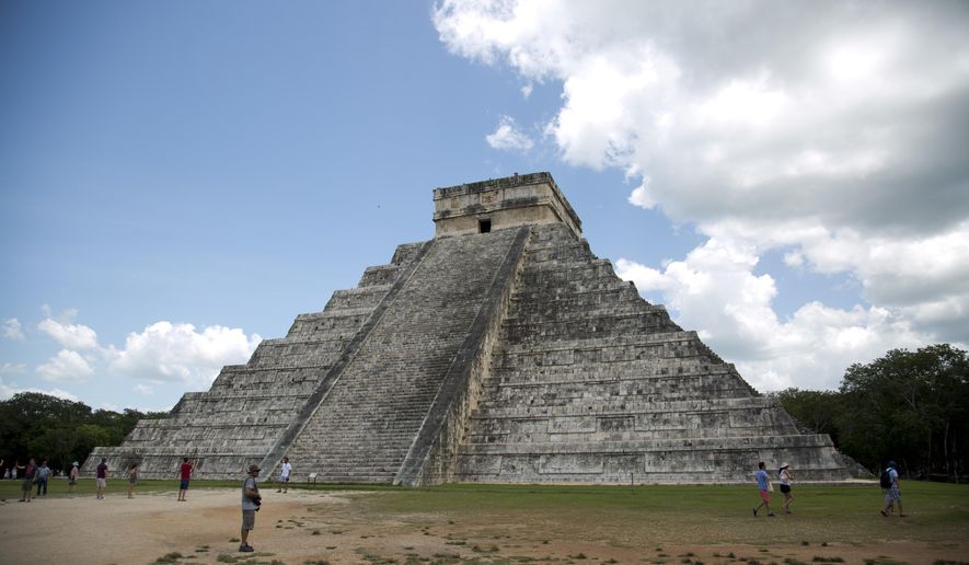 In this Aug. 3, 2018 file photo, tourists walk at the Mayan ruins of Chichen Itza in Mexico&#39;s Yucatan Peninsula. Experts in Mexico said Wednesday, Oct. 14, 2020, that they have detected more than 2,000 pre-Hispanic ruins or clusters of artefacts along the proposed route of the president&#39;s controversial “Maya Train” project on the Yucatan peninsula, which could slow down the already disputed project. (AP Photo/Eduardo Verdugo) **FILE**