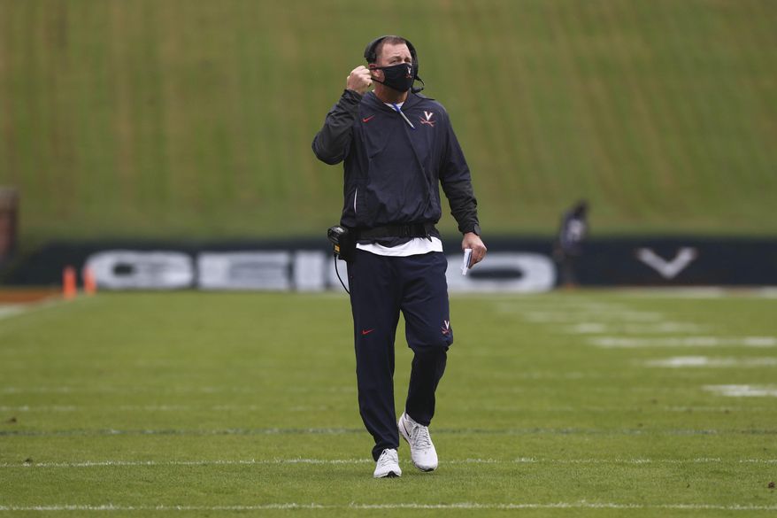 Virginia head coach Bronco Mendenhall adjusts his mask during an NCAA college football game against North Carolina State Saturday, Oct. 10, 2020, at Scott Stadium in Charlottesville, Va. (Erin Edgerton/The Daily Progress via AP)