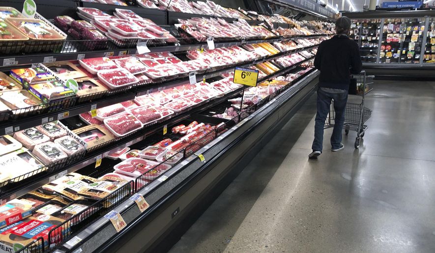FILE - In this May 10, 2020 file photo, a shopper pushes his cart past a display of packaged meat in a grocery store in southeast Denver. U.S. wholesale prices jumped 0.4% in September as food costs rose by the largest amount since May. The Labor Department said Wednesday, Oct. 14, that the September increase in its producer price index, which measures inflation before it reaches the consumer, followed a 0.3% rise in August and a 0.6% surge in July which had been the biggest monthly gain since late 2018. (AP Photo/David Zalubowski, File)
