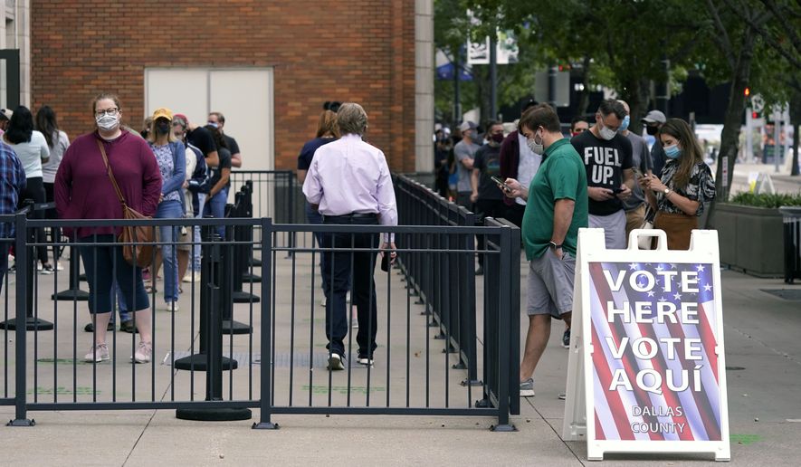Voters line up and wait to cast a ballot at the American Airlines Center during early voting Thursday, Oct. 15, 2020, in Dallas. (AP Photo/LM Otero)