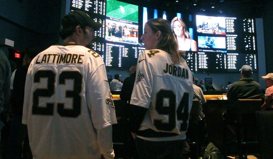 This Sept. 9, 2018 photo shows football fans waiting for kickoff in the sports betting lounge at the Ocean Casino Resort in Atlantic City, N.J. Figures released on Thursday, Oct. 15, 2020 showed New Jersey broke its own recently set U.S. record for the most money bet on sports in a single month in September when gamblers plunked down more than $748 million on sports. (AP Photo/Wayne Parry)