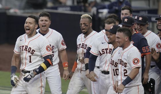 Players celebrate Houston Astros Carlos Correa&#39;s (1) walk off home run during the ninth inning in Game 5 of a baseball American League Championship Series, Tuesday, Dec. 15, 2020, in San Diego. The Astros defeated the Rays 4-3 and the Rays lead the series 3-2 games. (AP Photo/Gregory Bull)