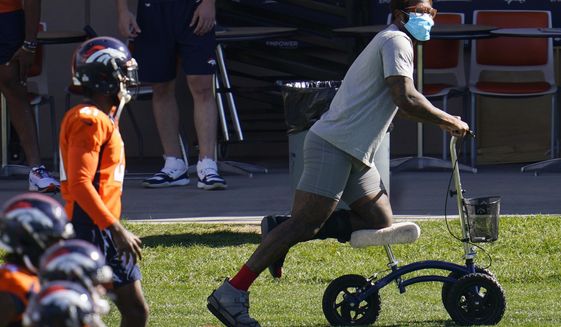 Injured Denver Broncos outside linebacker Von Miller uses a scooter to maneuver around as his teammates warm up before taking part in drills during an NFL football practice Wednesday, Oct. 14, 2020, at the team&#39;s headquarters in Englewood, Colo. (AP Photo/David Zalubowski)