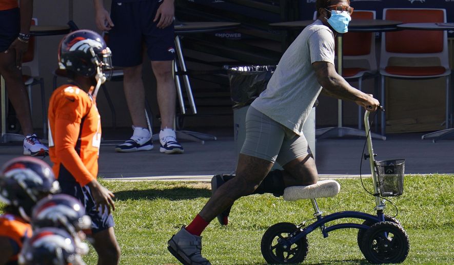 Injured Denver Broncos outside linebacker Von Miller uses a scooter to maneuver around as his teammates warm up before taking part in drills during an NFL football practice Wednesday, Oct. 14, 2020, at the team&#x27;s headquarters in Englewood, Colo. (AP Photo/David Zalubowski)