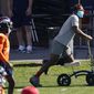 Injured Denver Broncos outside linebacker Von Miller uses a scooter to maneuver around as his teammates warm up before taking part in drills during an NFL football practice Wednesday, Oct. 14, 2020, at the team&#x27;s headquarters in Englewood, Colo. (AP Photo/David Zalubowski)