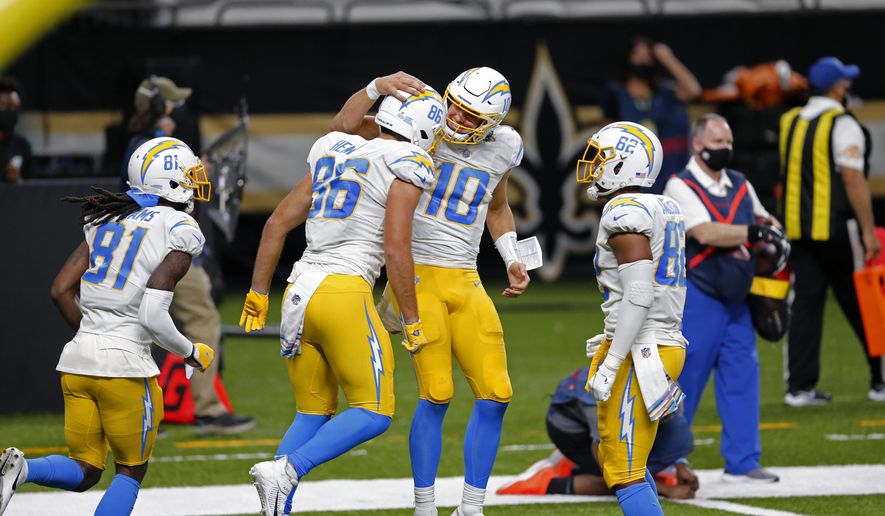 Los Angeles Chargers quarterback Justin Herbert (10) and tight end Hunter Henry (86) celebrate their touchdown pass in the first half of an NFL football game against the New Orleans Saints in New Orleans, Monday, Oct. 12, 2020. (AP Photo/Brett Duke)