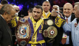 FILE - In this April 12, 2019, file photo, Vasiliy Lomachenko celebrates defending his WBA/WBO lightweight titles after knocking out Anthony Crolla, in Los Angeles. Lomachenko fights Teofimo Lopez on Saturday, Oct. 17, 2020, in Las Vegas. Boxing fans should be thankful. They’re getting a quality fight _ and they’re getting it for free.(AP Photo/Damian Dovarganes, File)