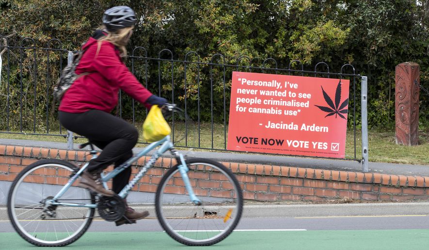A cyclist rides past a sign in support of making marijuana legal in Christchurch, New Zealand, Thursday, Oct. 15, 2020. New Zealanders are poised to decide on two crucial social issues during an election on Saturday, Oct. 17, whether to legalize recreational marijuana and whether to legalize euthanasia. (AP Photo/Mark Baker)