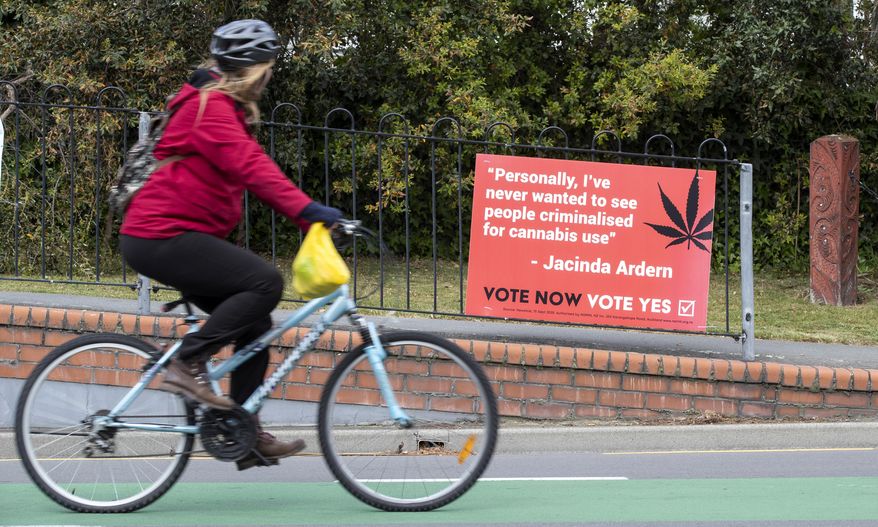 A cyclist rides past a sign in support of making marijuana legal in Christchurch, New Zealand, Thursday, Oct. 15, 2020. New Zealanders are poised to decide on two crucial social issues during an election on Saturday, Oct. 17, whether to legalize recreational marijuana and whether to legalize euthanasia. (AP Photo/Mark Baker)