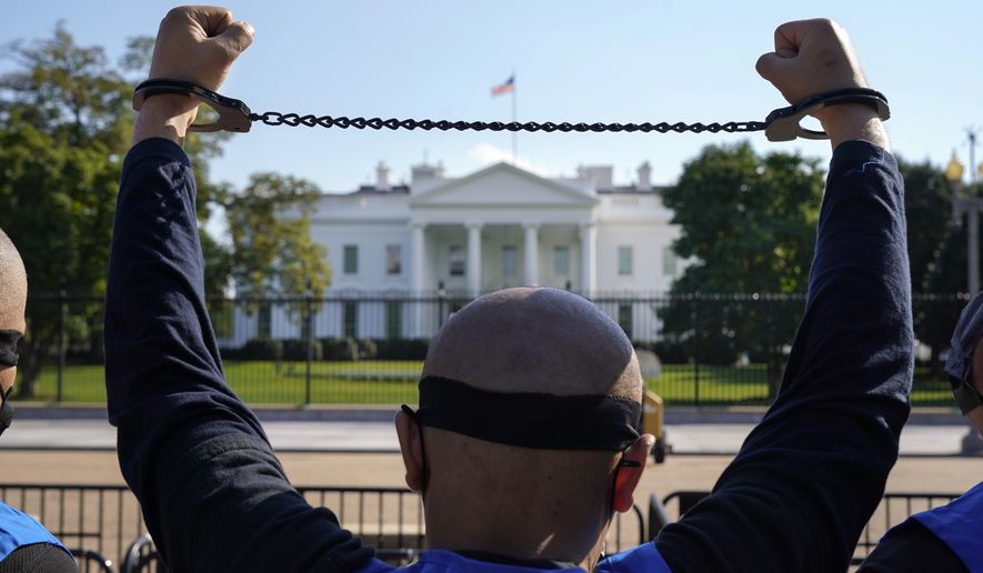 A member of the Uyghur American Association rallies in front of the White House, Thursday, Oct. 1, 2020, after marching from Capitol Hill in Washington, in support of the Uyghur Forced Labor Prevention Act which has passed the House and now will go on to the Senate. The bill prohibits some imports from Xinjiang and imposes sanctions for human rights violations. (AP Photo/Jacquelyn Martin)
