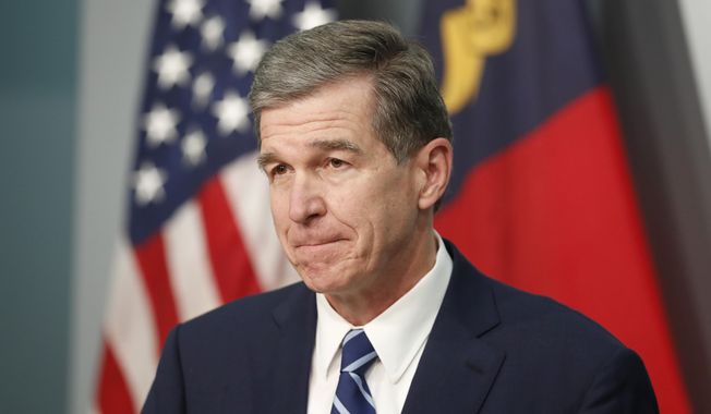 North Carolina Gov. Roy Cooper listens to a question during a briefing at the Emergency Operations Center in Raleigh, N.C., Thursday, Oct. 15, 2020. (Ethan Hyman/The News &amp;amp; Observer via AP)