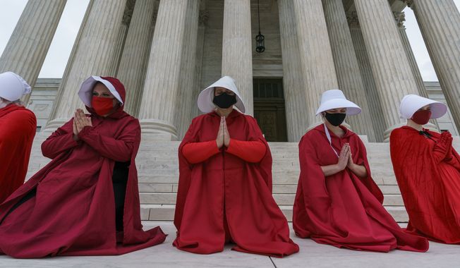 Activists opposed to the confirmation of President Donald Trump&#x27;s Supreme Court nominee, Judge Amy Coney Barrett, are dressed as characters from &quot;The Handmaid&#x27;s Tale,&quot; at the Supreme Court on Capitol Hill in Washington, Sunday, Oct. 11, 2020. (AP Photo/J. Scott Applewhite) ** FILE **