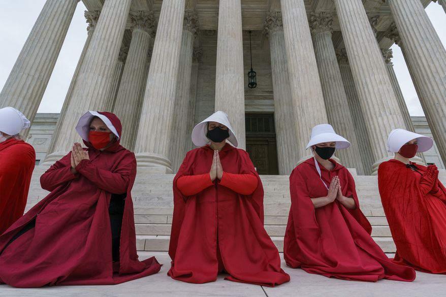Activists opposed to the confirmation of President Donald Trump's Supreme Court nominee, Judge Amy Coney Barrett, are dressed as characters from "The Handmaid's Tale," at the Supreme Court on Capitol Hill in Washington, Sunday, Oct. 11, 2020. (AP Photo/J. Scott Applewhite) ** FILE **