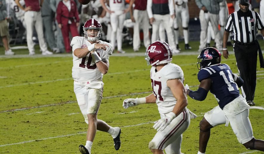 Alabama quarterback Mac Jones (10) throws a 3-yard touchdown pass to tight end Miller Forristall (87) as Mississippi linebacker Daylen Gill (14) defends during the second half of an NCAA college football game in Oxford, Miss., Saturday, Oct. 10, 2020. Alabama won 63-48. (AP Photo/Rogelio V. Solis)