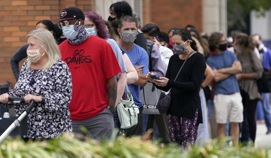 Voters line up and wit to cast a ballot at the American Airlines Center during early voting Thursday, Oct. 15, 2020, in Dallas. (AP Photo/LM Otero)