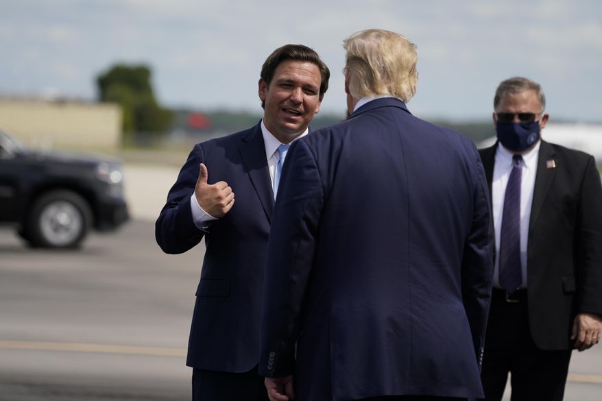 In this file photo, President Donald Trump speaks with Florida Gov. Ron DeSantis as he arrives at Southwest Florida International Airport, Friday, Oct. 16, 2020, in Fort Myers, Fla. (AP Photo/Evan Vucci)