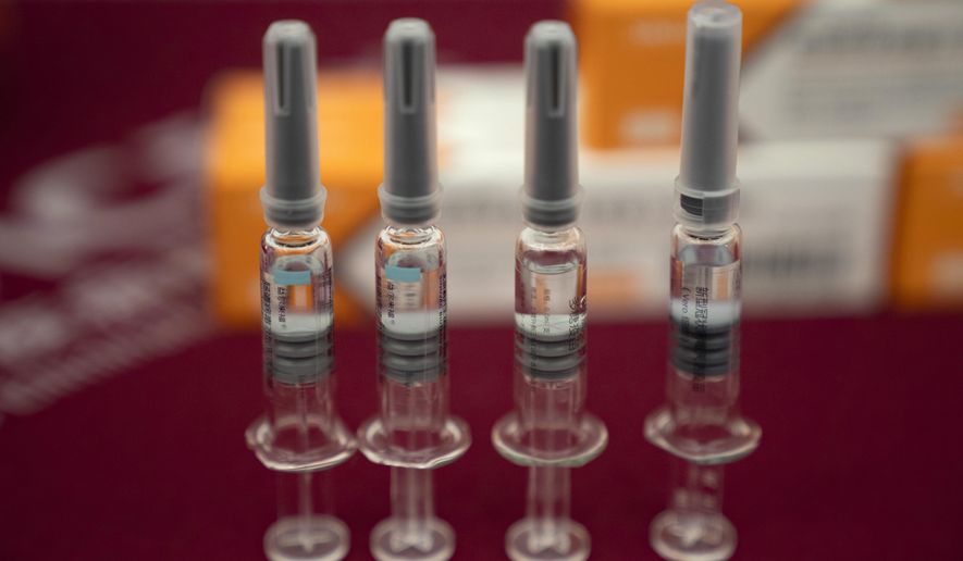 In this Sept. 24, 2020, file photo, syringes of SARS CoV-2 Vaccine for COVID-19 produced by Sinovac are displayed during a media tour of its factory in Beijing. China is rapidly increasing the number of people receiving its experimental coronavirus vaccines, with a city offering one to the general public and a biotech company providing another free to students going abroad. (AP Photo/Ng Han Guan, File)