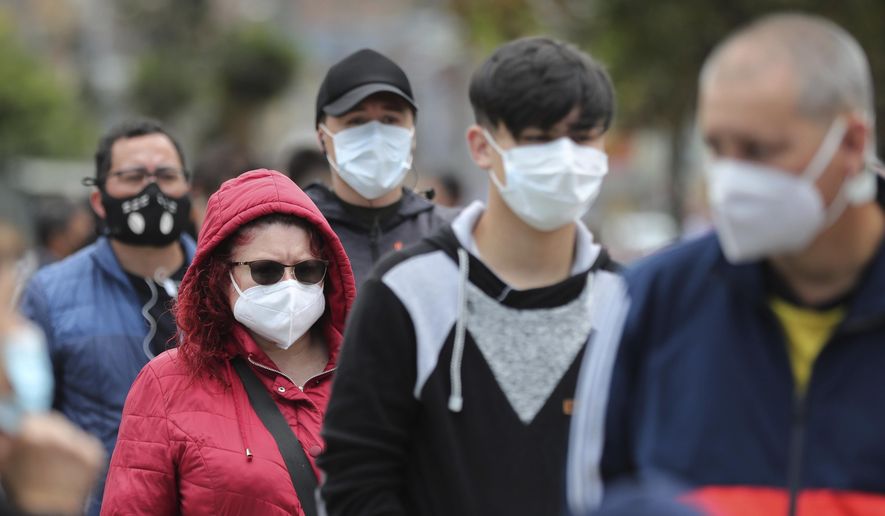 Residents line up to take a nasal swab sample for COVID-19 tests, provided for free by the municipal government in Bogota, Colombia, Friday, Oct. 16, 2020. (AP Photo/Fernando Vergara)