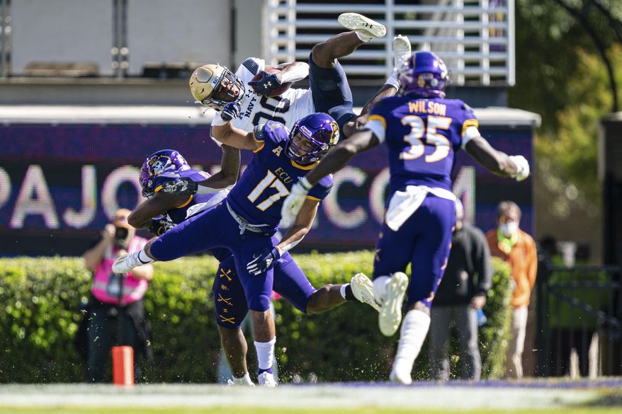 Navy wide receiver Mark Walker (80) tries to hurdle over East Carolina defensive back Warren Saba (17) during an NCAA football game on Saturday, Oct. 17, 2020, in Greenville, N.C. (AP Photo/Jacob Kupferman)