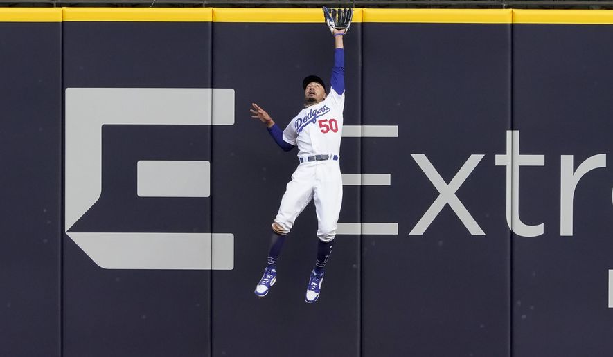 Los Angeles Dodgers right fielder Mookie Betts robs Atlanta Braves&#39; Marcell Ozuna of a home during the fifth inning in Game 6 of a baseball National League Championship Series Saturday, Oct. 17, 2020, in Arlington, Texas. (AP Photo/Tony Gutierrez)
