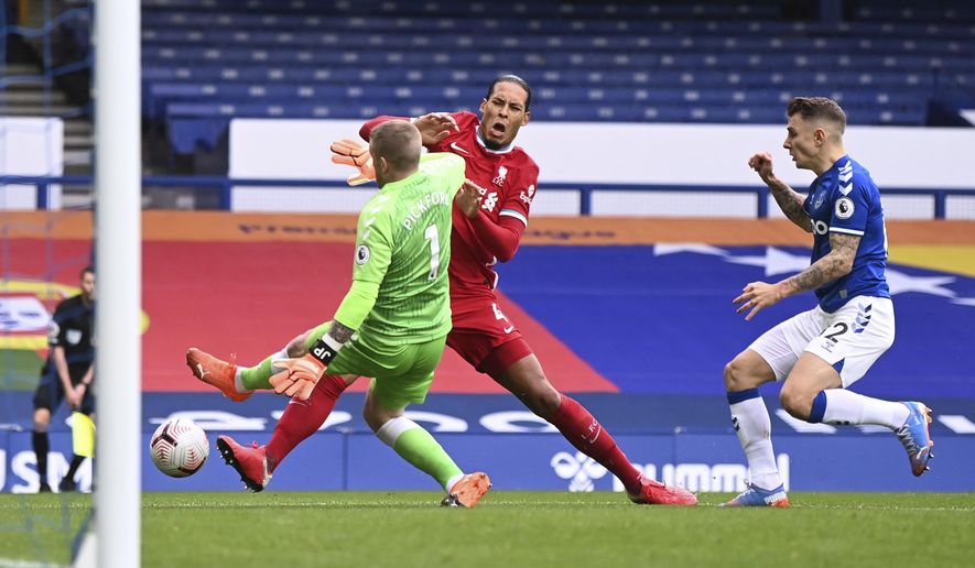 Liverpool&#39;s Virgil van Dijk, centre, is tackled and injured by Everton&#39;s goalkeeper Jordan Pickford, left, causing him to leave the match injured during the English Premier League soccer match between Everton and Liverpool at Goodison Park stadium, in Liverpool, England, Saturday, Oct. 17, 2020. (Laurence Griffiths/Pool via AP)