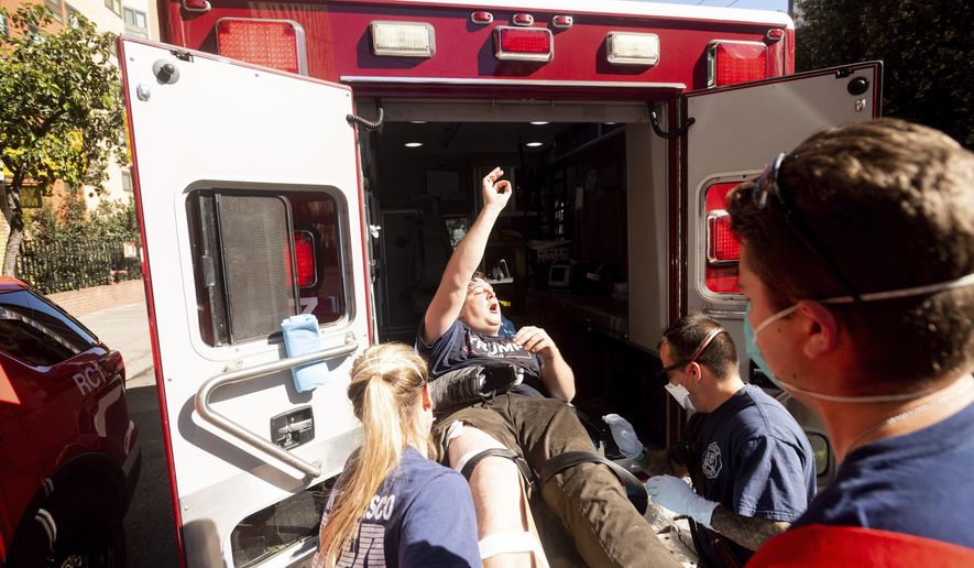 Medics transport a supporter of President Donald Trump to an ambulance after he was attacked by counter-protesters in San Francisco on Saturday, Oct. 17, 2020. About a dozen pro-Trump demonstrators were met by several hundred counter-protesters as they tried to rally. (AP Photo/Noah Berger)