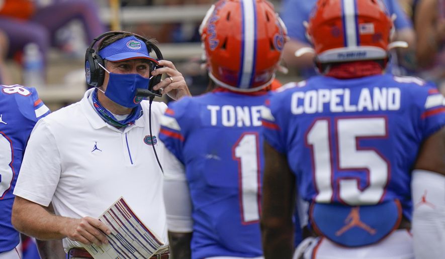 Florida head coach Dan Mullen, left, talks with wide receivers Kadarius Toney (1) and Jacob Copeland (15) during a timeout in the first half of an NCAA college football game against South Carolina, Saturday, Oct. 3, 2020, in Gainesville, Fla. (AP Photo/John Raoux, Pool)