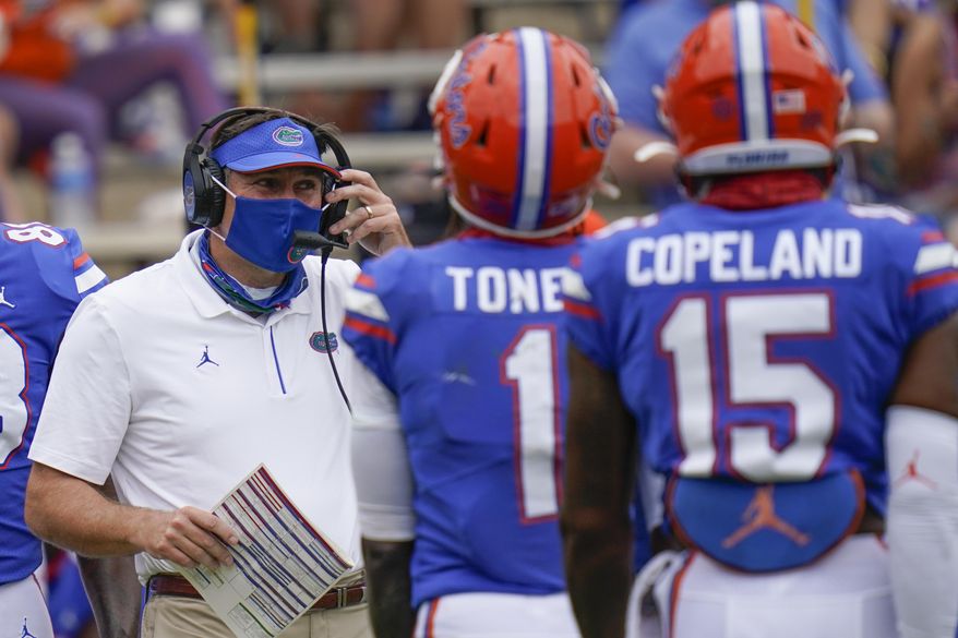 Florida head coach Dan Mullen, left, talks with wide receivers Kadarius Toney (1) and Jacob Copeland (15) during a timeout in the first half of an NCAA college football game against South Carolina, Saturday, Oct. 3, 2020, in Gainesville, Fla. (AP Photo/John Raoux, Pool)