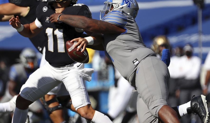Memphis defensive lineman O'Bryan Goodson (1) drags down Central Florida quarterback Dillon Gabriel (11) during an NCAA college football game Saturday, Oct. 17, 2020, in Memphis, Tenn. (Patrick Lantrip/Daily Memphian via AP)