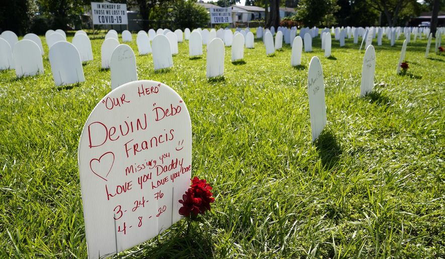White plastic tombstone-shaped pieces are lined up as part of a temporary memorial to some of Miami&#39;s victims of the coronavirus at Simonhoff Floral Park, Wednesday, Oct. 14, 2020, in the Liberty City neighborhood of Miami. (AP Photo/Lynne Sladky)