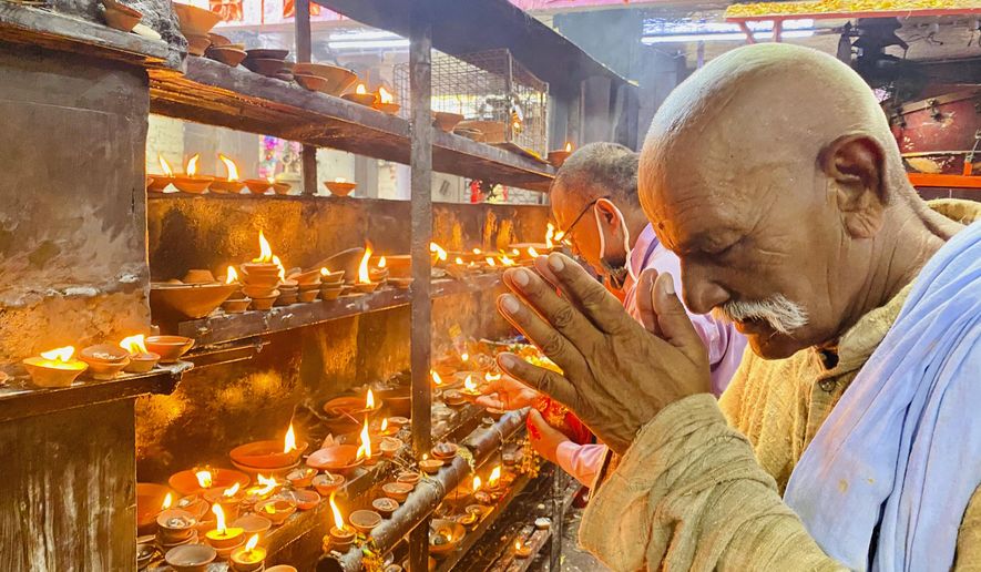 An elderly Hindu offers prayers at the Vindhyavasini temple in Mirzapur in the northern Indian state of Uttar Pradesh, Saturday, Oct. 17, 2020. Health officials have warned about the potential for the coronavirus to spread during the upcoming religious festival season, which is marked by huge gatherings in temples and shopping districts. (AP Photo/Rajesh Kumar Singh)