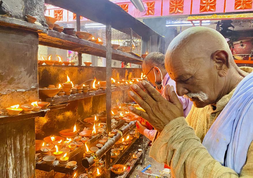 An elderly Hindu offers prayers at the Vindhyavasini temple in Mirzapur in the northern Indian state of Uttar Pradesh, Saturday, Oct. 17, 2020. Health officials have warned about the potential for the coronavirus to spread during the upcoming religious festival season, which is marked by huge gatherings in temples and shopping districts. (AP Photo/Rajesh Kumar Singh)