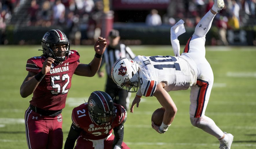 Auburn quarterback Bo Nix (10) is knocked out of bounds by South Carolina defensive back Shilo Sanders (21) and Kingsley Enagbare (52) during the second half of an NCAA college football game Saturday, Oct. 17, 2020, in Columbia, S.C. South Carolina defeated Auburn 30-22. (AP Photo/Sean Rayford)


